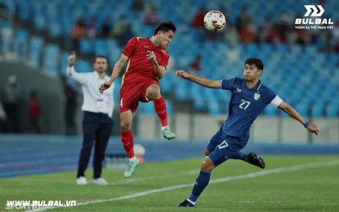 Cầu thủ đang sẵn sàng cho tư thế phòng ngự không chiến trong bóng đá, chuẩn bị tranh chấp bóng bổng.