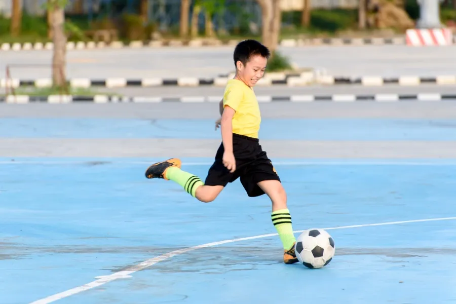 Trẻ em chơi bóng đá trên sân cỏ