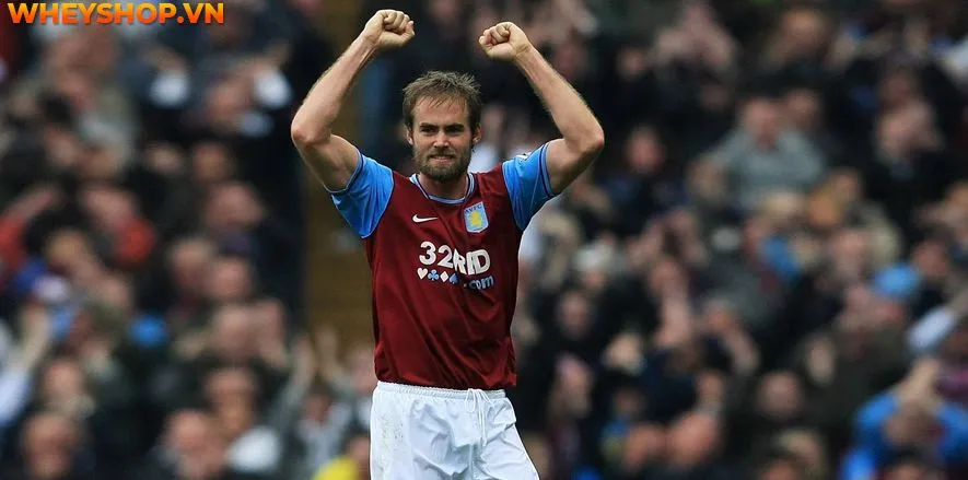 Olof Mellberg, cầu thủ bóng đá Aston Villa, thể hiện sự bất lực sau tình huống ném biên vô tình đá phản lưới nhà, một ví dụ về những khoảnh khắc không mong muốn trong đá bóng.