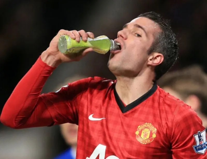 Cầu thủ bóng đá đang uống nước chanh muối để bù điện giải, cung cấp năng lượng và khoáng chất cần thiết khi đá bóng