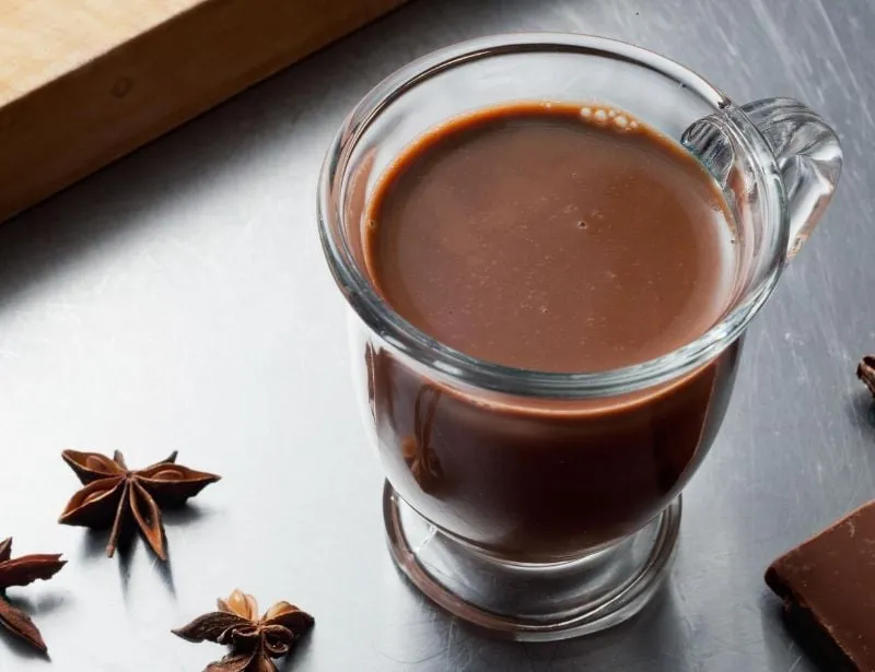 Một cầu thủ bóng đá đang uống sữa socola để phục hồi thể lực nhanh chóng sau trận đấu, cung cấp năng lượng và dưỡng chất cần thiết